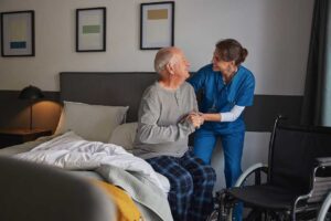 Older adult choosing breakfast in a bright assisted living dining room with a caregiver nearby