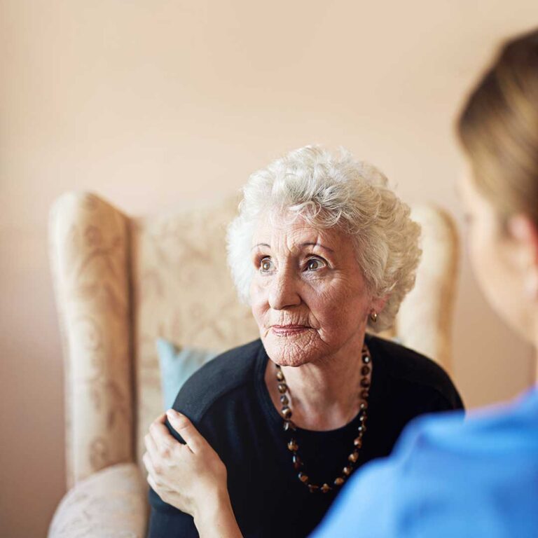 Family member and older adult reviewing care options at a table with notes and a calendar.